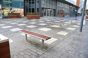 Photo of outdoor space with a coloured paving in a pattern